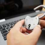 Padlock held over a laptop.